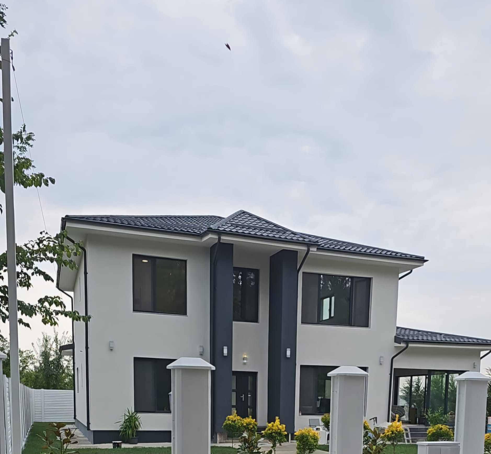 Façade extérieure d'une maison moderne rénovée avec toiture en tuiles et bardage anthracite